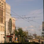 Street scene in downtown Houston featuring historic buildings and a train under a clear blue sky.
