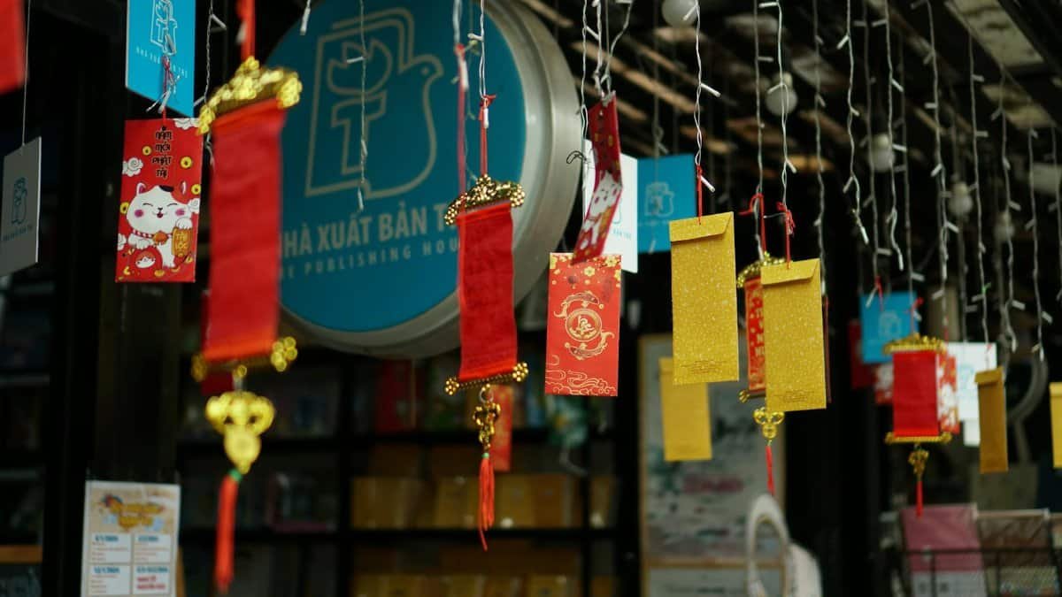 Colorful red and gold lanterns hang at an outdoor market celebrating Lunar New Year.