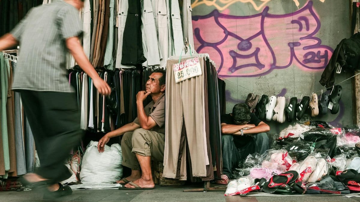 Busy street market in Bandung, showcasing clothing display and local vendors.