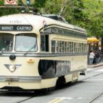 A charming streetcar travels through San Francisco's bustling cityscape on the F Market & Castro line.