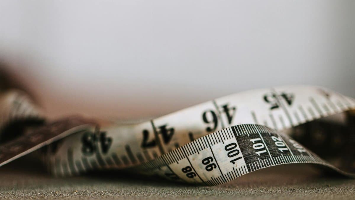 Artistic shallow focus image of a measuring tape showing numbers and units.