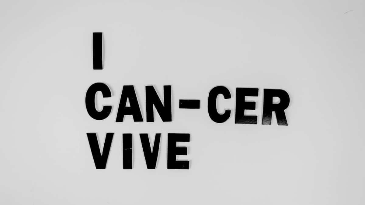 Creative message symbolizing cancer survival with black letters on white background.