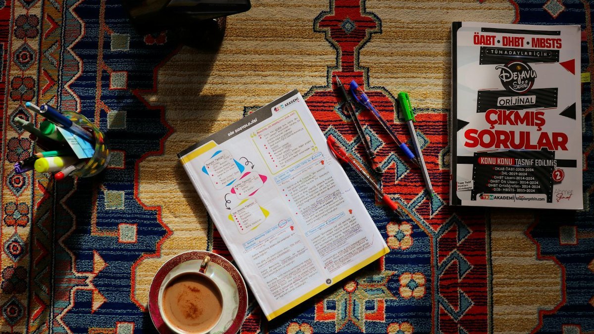Top view of study materials and coffee on a patterned carpet. Perfect for academic or study themes.