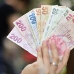 A variety of Turkish Lira in hand, showing multiple banknote denominations.