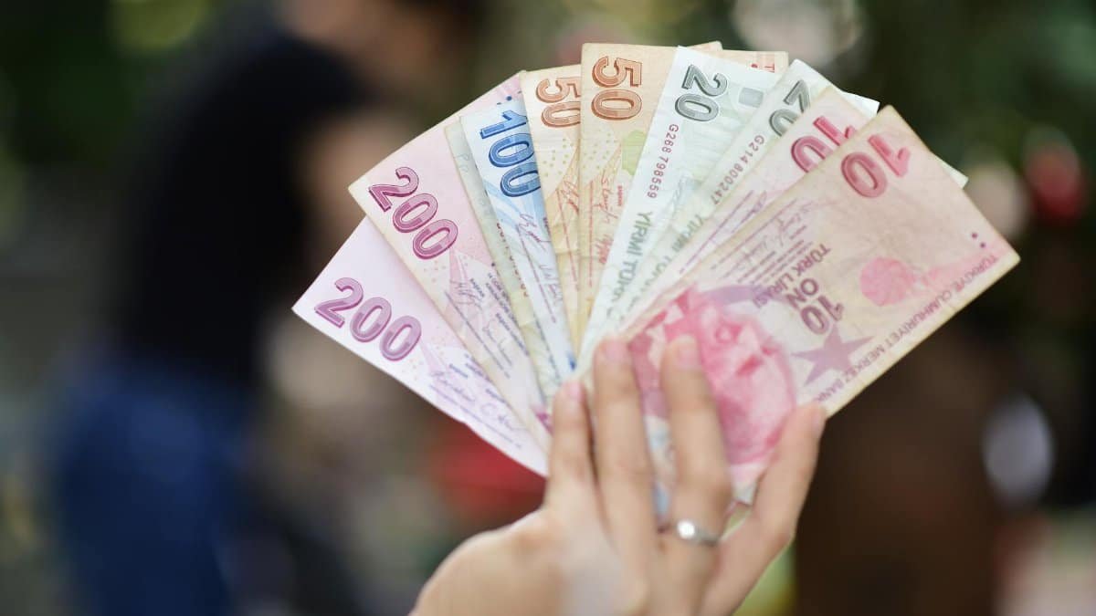 A variety of Turkish Lira in hand, showing multiple banknote denominations.