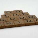 Scrabble tiles arranged to spell 'Do the good thing' on a white surface.
