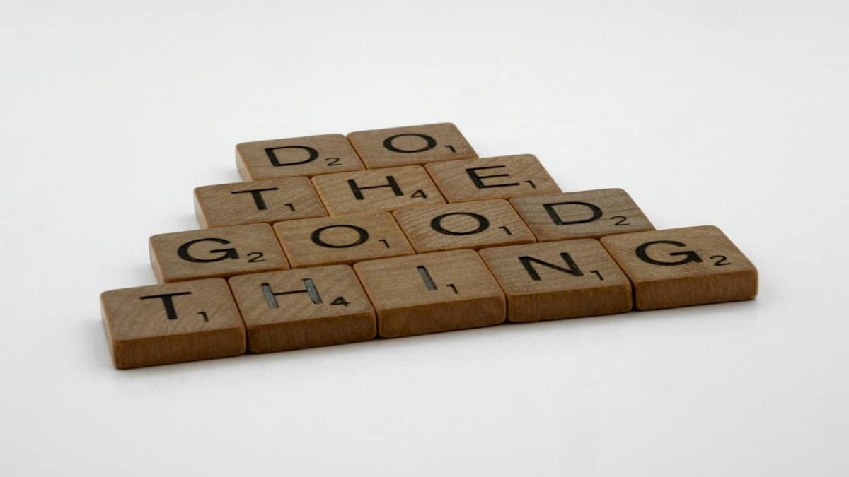 Scrabble tiles arranged to spell 'Do the good thing' on a white surface.