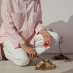 Woman planting and tending to small plants and flowers indoors.