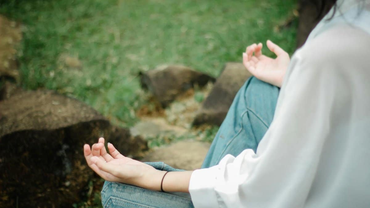 A person meditates outdoors, embracing tranquility and mindfulness.