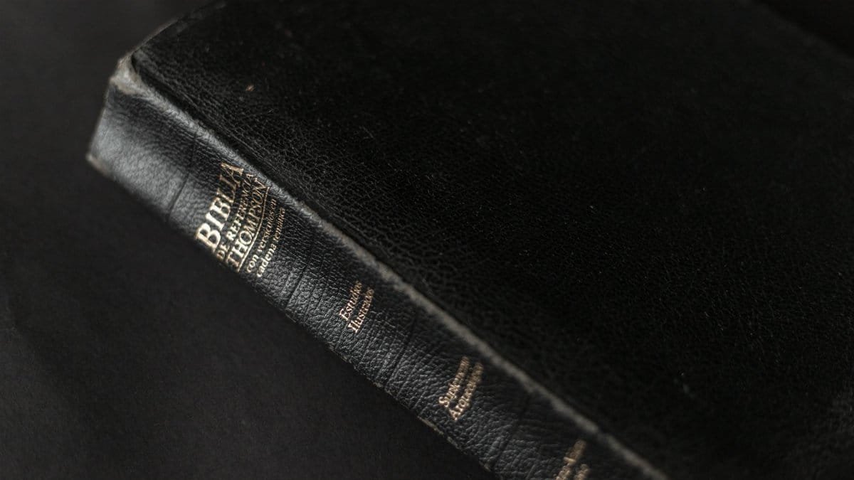 A black leather Bible with gold lettering on the spine, showcasing its textured cover.