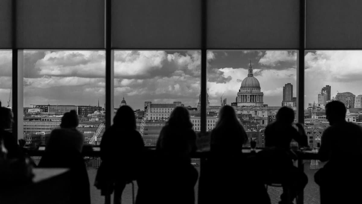 Black and white photo of people silhouetted against the London skyline featuring St. Paul's Cathedral.