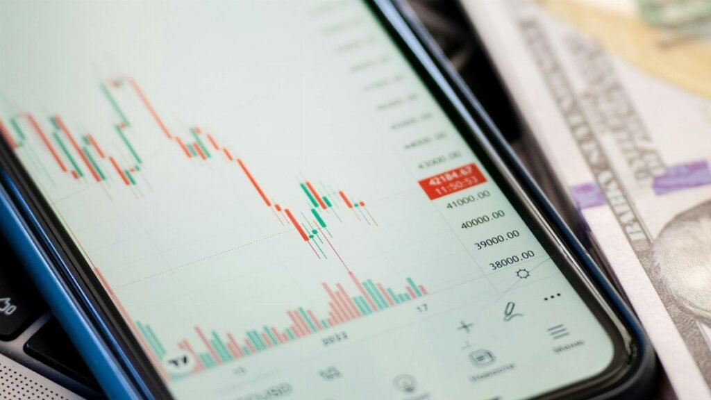 Detailed view of stock market data on a smartphone with US dollars in the background, illustrating trading.
