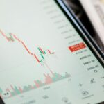 Detailed view of stock market data on a smartphone with US dollars in the background, illustrating trading.