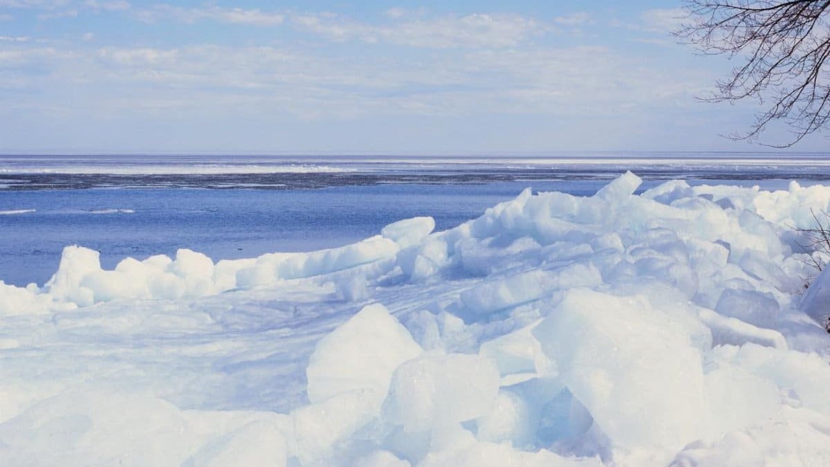 Experience stark beauty at a frozen lake in Minnesota. Capturing peaceful winter landscape with ice floes and blue sky.