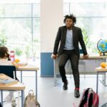 A teacher engages with students in a bright, modern classroom setting, promoting education.