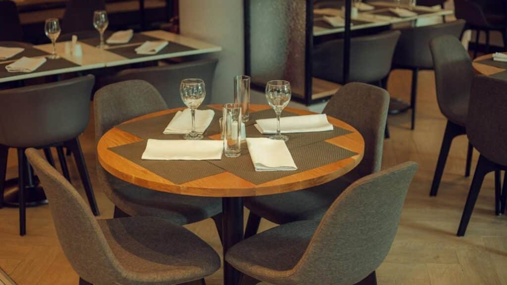 Chic restaurant table with modern decor, glassware, and cutlery, ready for guests.