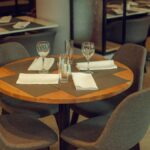Chic restaurant table with modern decor, glassware, and cutlery, ready for guests.