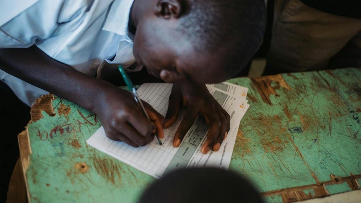 Focused student writing in a classroom setting, capturing educational engagement.