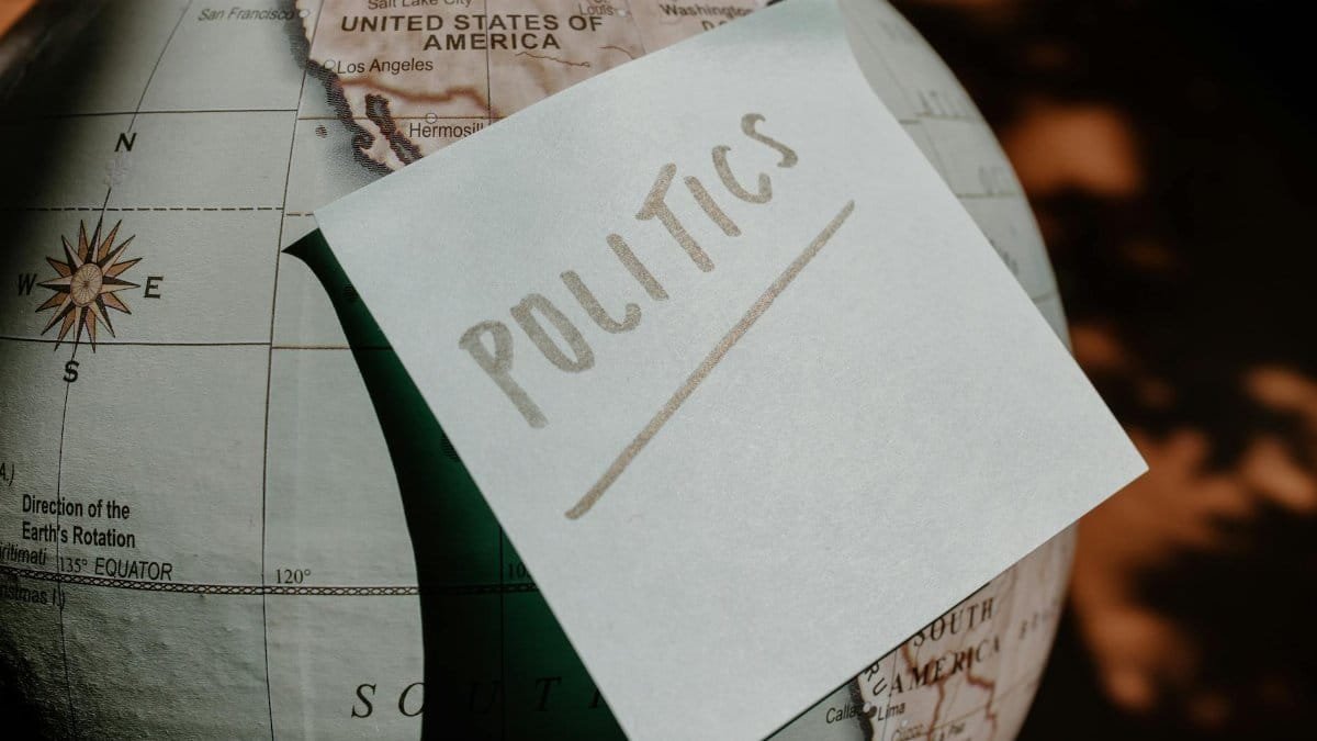 A close-up of a globe with a politics sticky note, symbolizing global political themes.