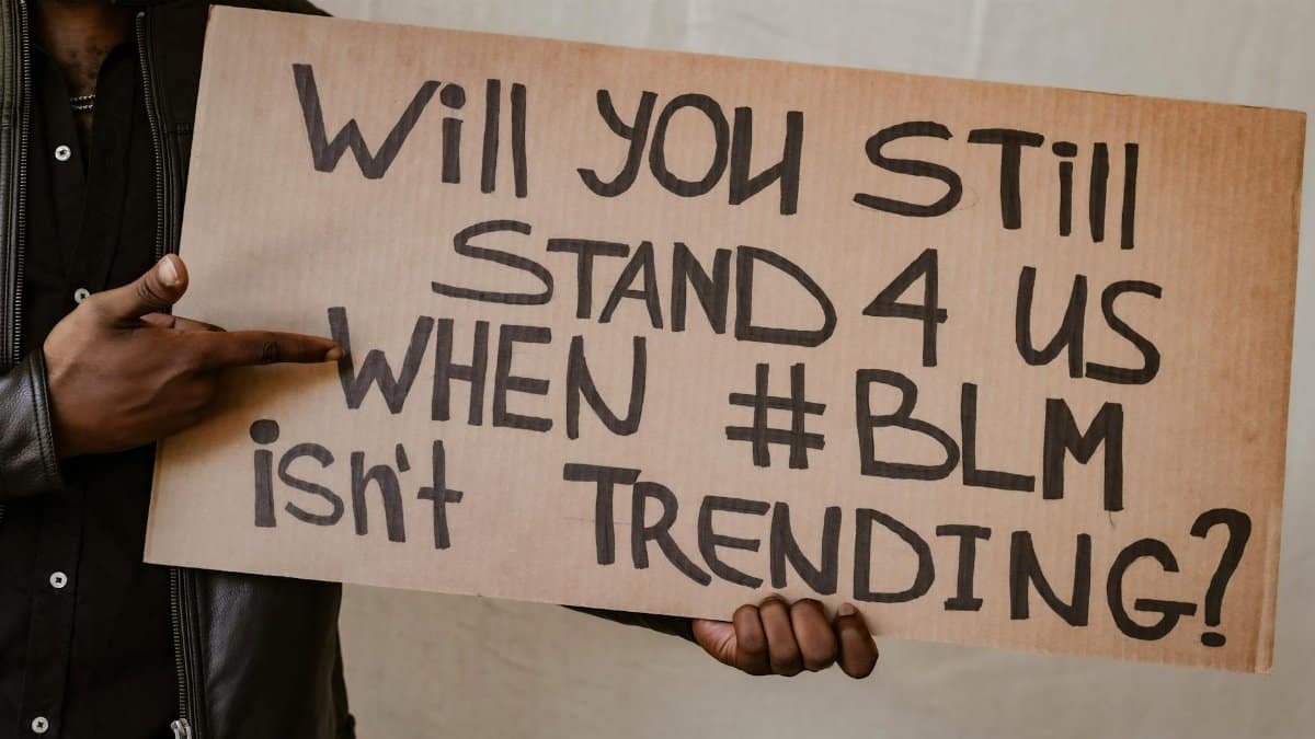 Close-up of a protest sign asking for support for BLM beyond trending topics, diversity focus.