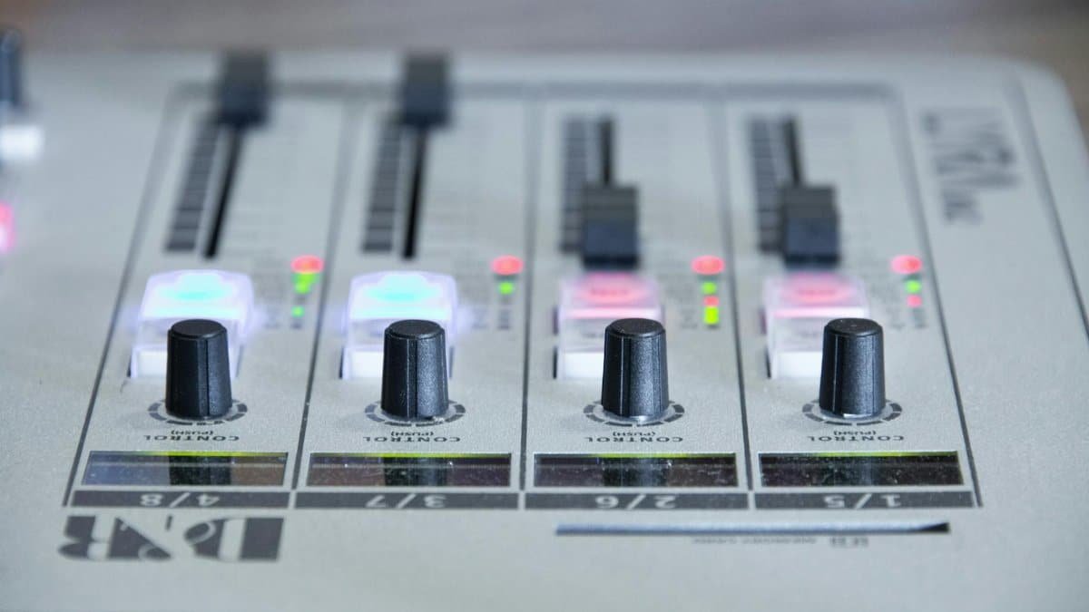 Detailed view of an audio mixer with knobs and control sliders for sound adjustment.