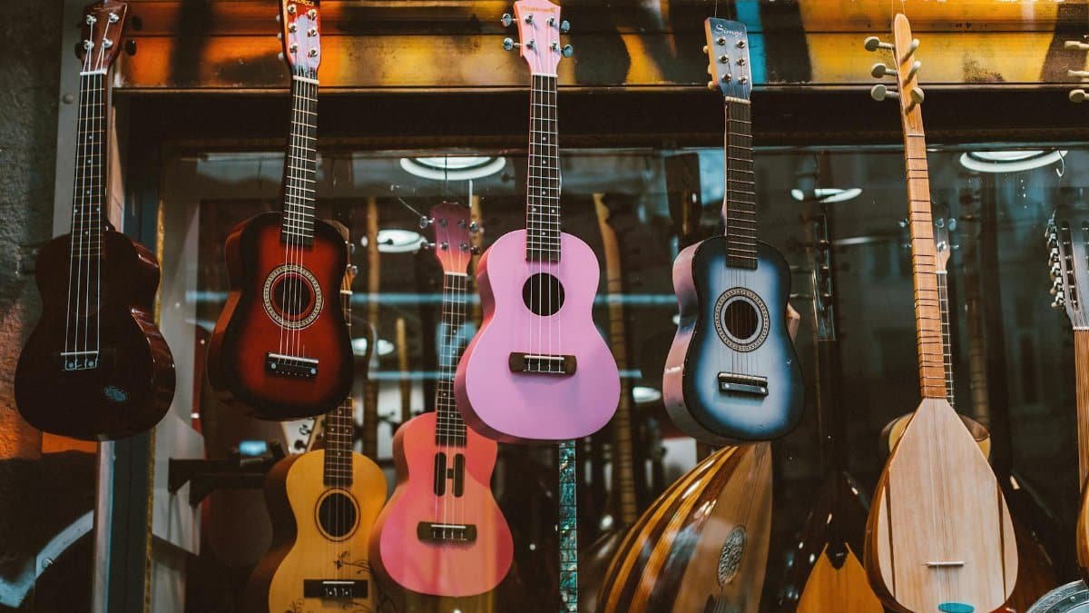 A colorful collection of ukuleles and mandolins hanging in a music store display, enhancing musical ambiance.