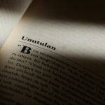 Moody close-up photo of a book page partially lit, highlighting text in Turkish.
