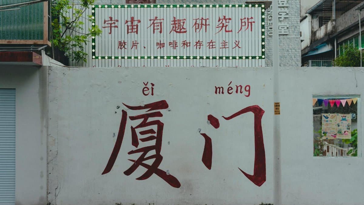 Urban scene featuring a wall with Chinese graffiti and colorful signage.