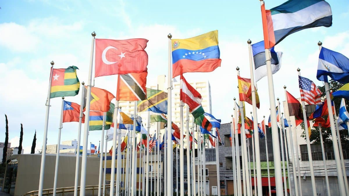 A vibrant collection of international flags in a cityscape setting, symbolizing global unity.