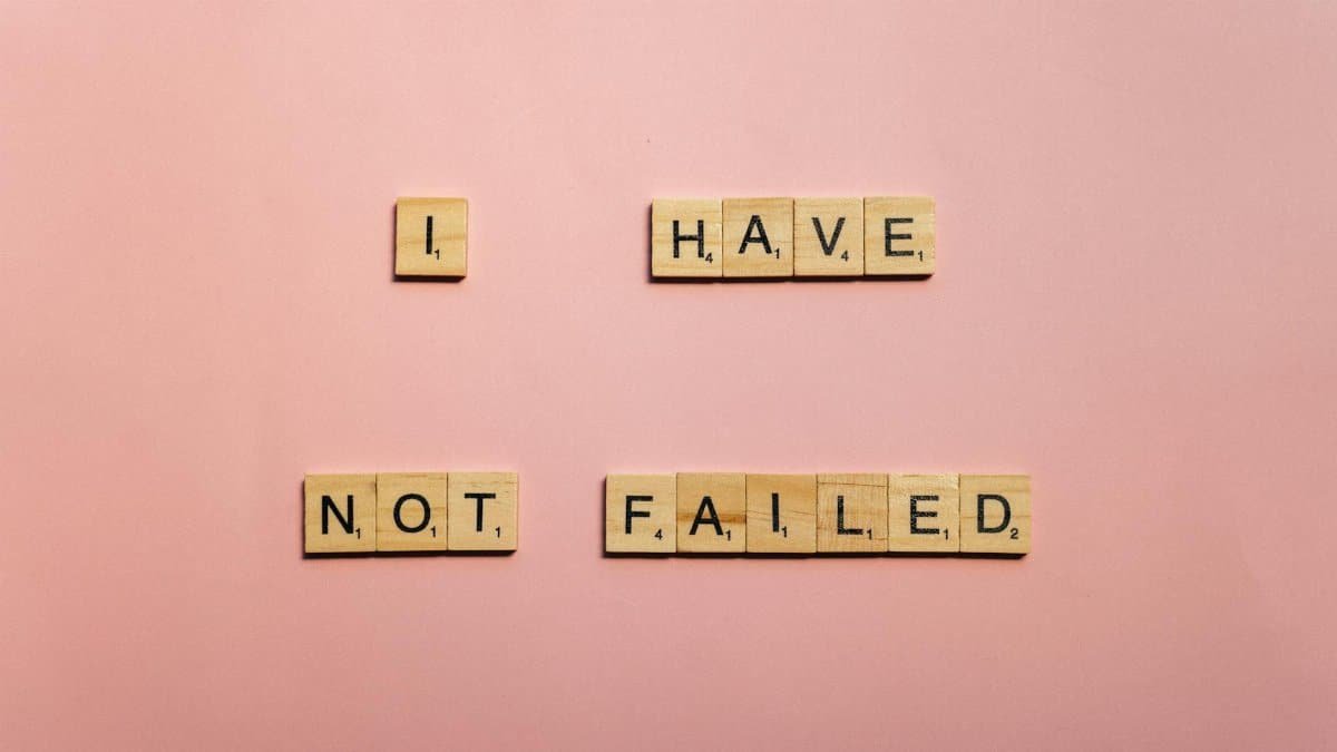 Scrabble tiles spelling 'I have not failed' on a pink background, offering an inspirational message.