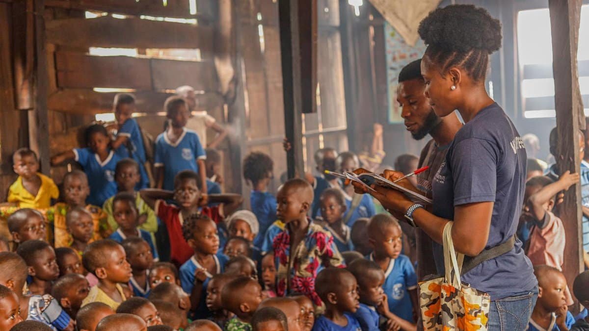 Volunteers conduct an educational session for children in an indoor community space.