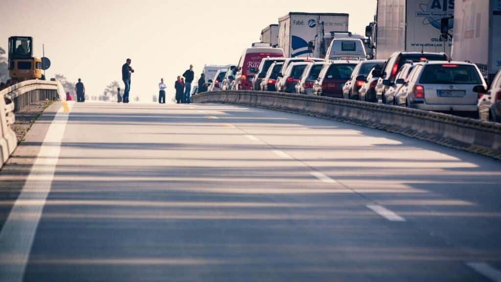 A congested highway with cars and trucks in a traffic jam during daylight.