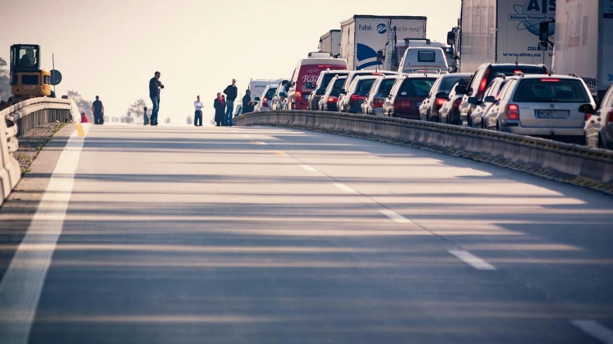 A congested highway with cars and trucks in a traffic jam during daylight.