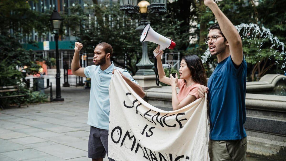 Group of activists with a megaphone rallying for change outdoors.