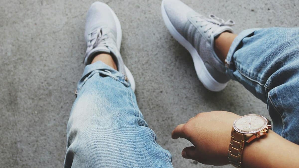 A casual and stylish look featuring denim jeans, sneakers, and a wristwatch.