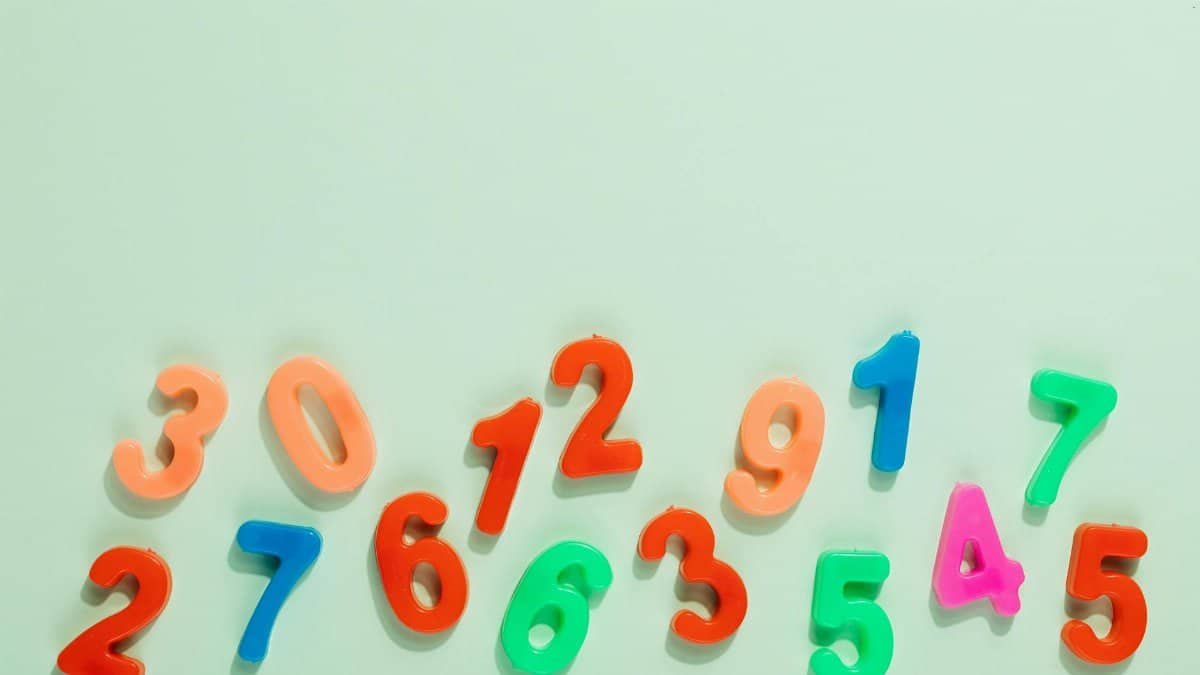 Bright plastic numbers on a mint green background for learning and education.