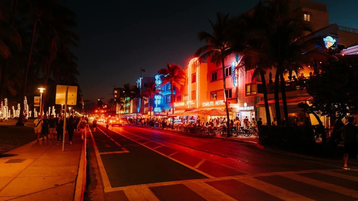 Lively Miami nightlife on Ocean Drive with illuminated Art Deco buildings and bustling streets.