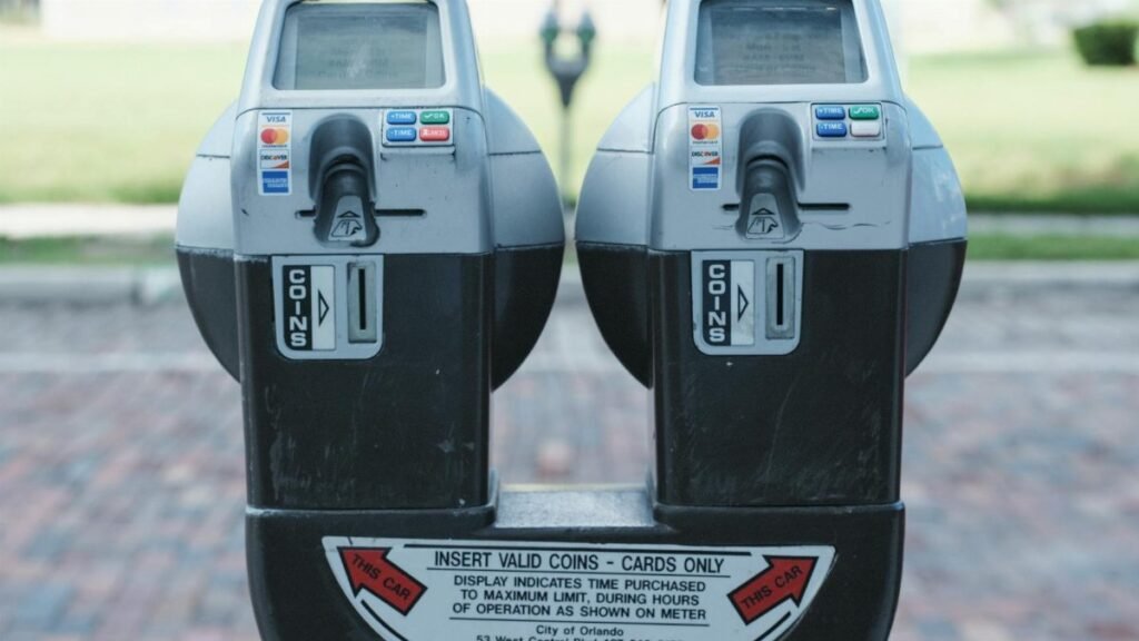 Photo of two parking meters in Orlando showing coin and card payment options on a brick road.