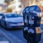 Close-up of parking meters in a bustling city street during the day, showcasing urban infrastructure.