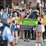 Protesters march in Chicago demanding police accountability. Diverse crowd carries signs for justice.