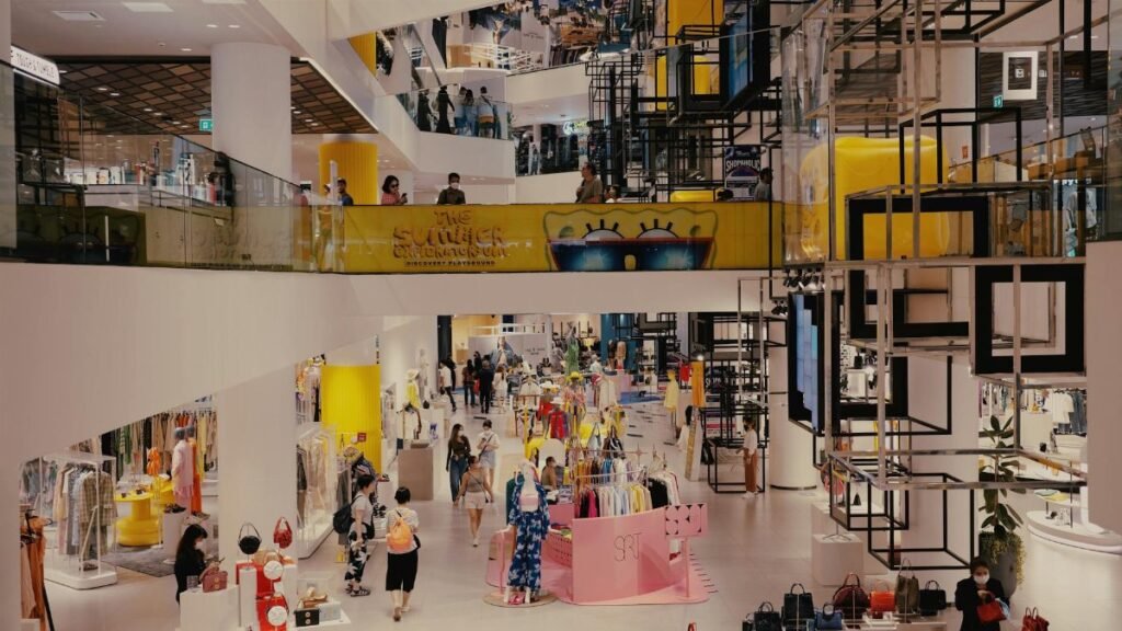 Vibrant mall filled with shoppers, contemporary decor, and stylish fashion outlets.