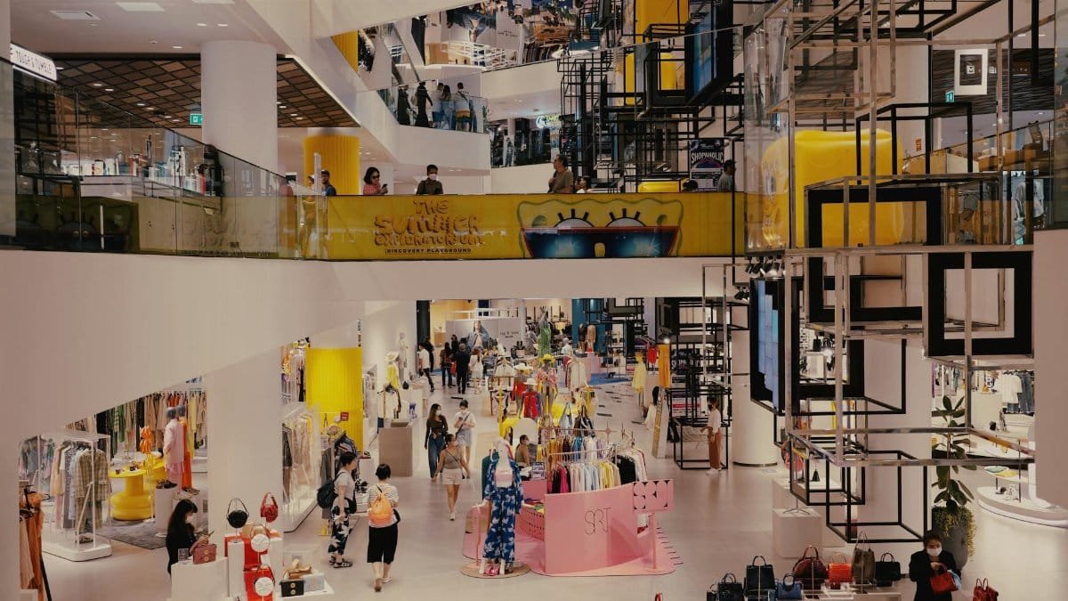 Vibrant mall filled with shoppers, contemporary decor, and stylish fashion outlets.