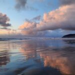Breathtaking sunset with stunning cloud reflections on a Pacific Northwest beach.