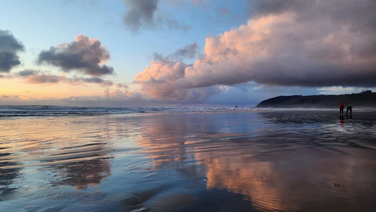 Breathtaking sunset with stunning cloud reflections on a Pacific Northwest beach.