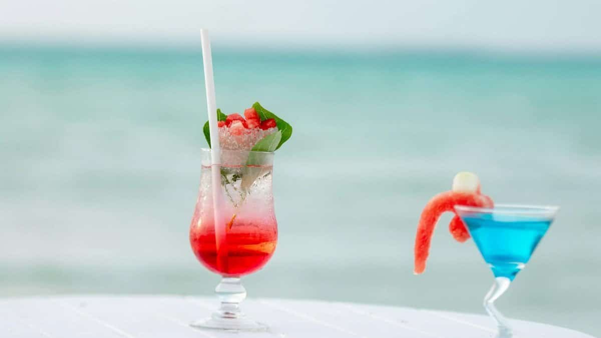 Colorful tropical cocktails on a beachside table in the Maldives with a scenic ocean view.