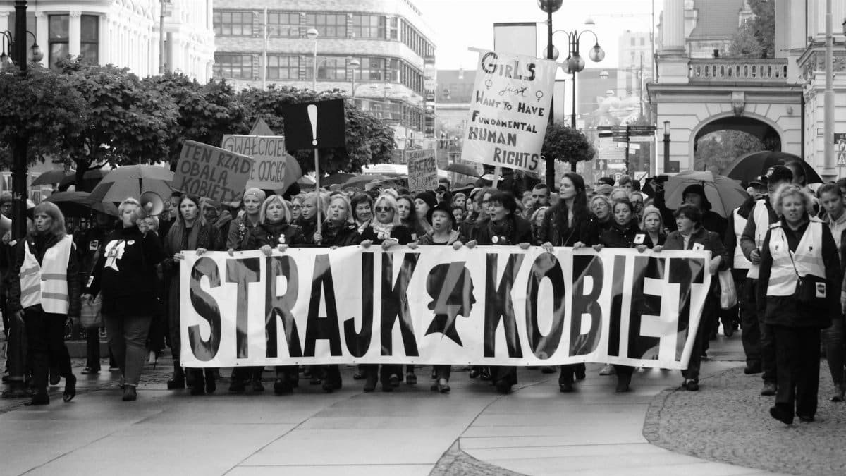 Black and white photo of a women's rights protest in an urban setting in Poland.