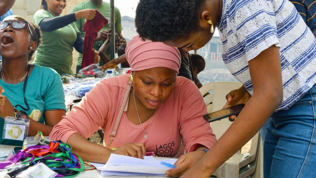 Group of volunteers working on registration at a community event outdoors.