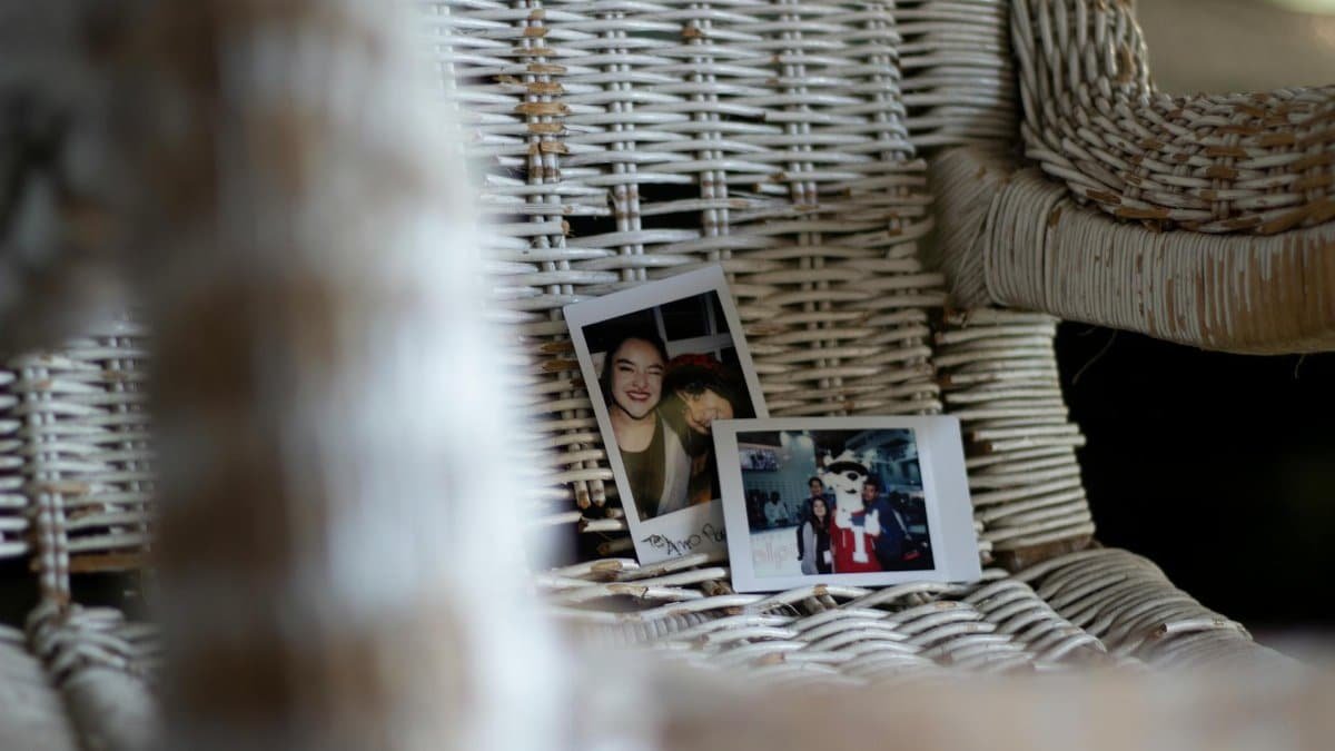 A cozy wicker chair with polaroid photos featuring happy moments creates a nostalgic mood.