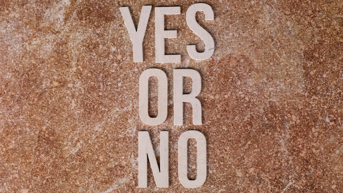 Wooden letters on marble background spell 'YES OR NO' symbolizing choices.