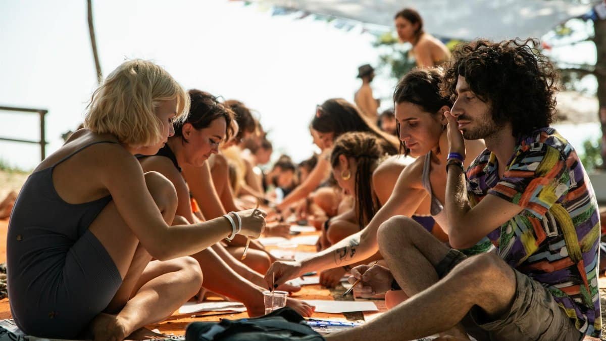 A diverse group engaged in an outdoor art workshop, enjoying creativity and collaboration.